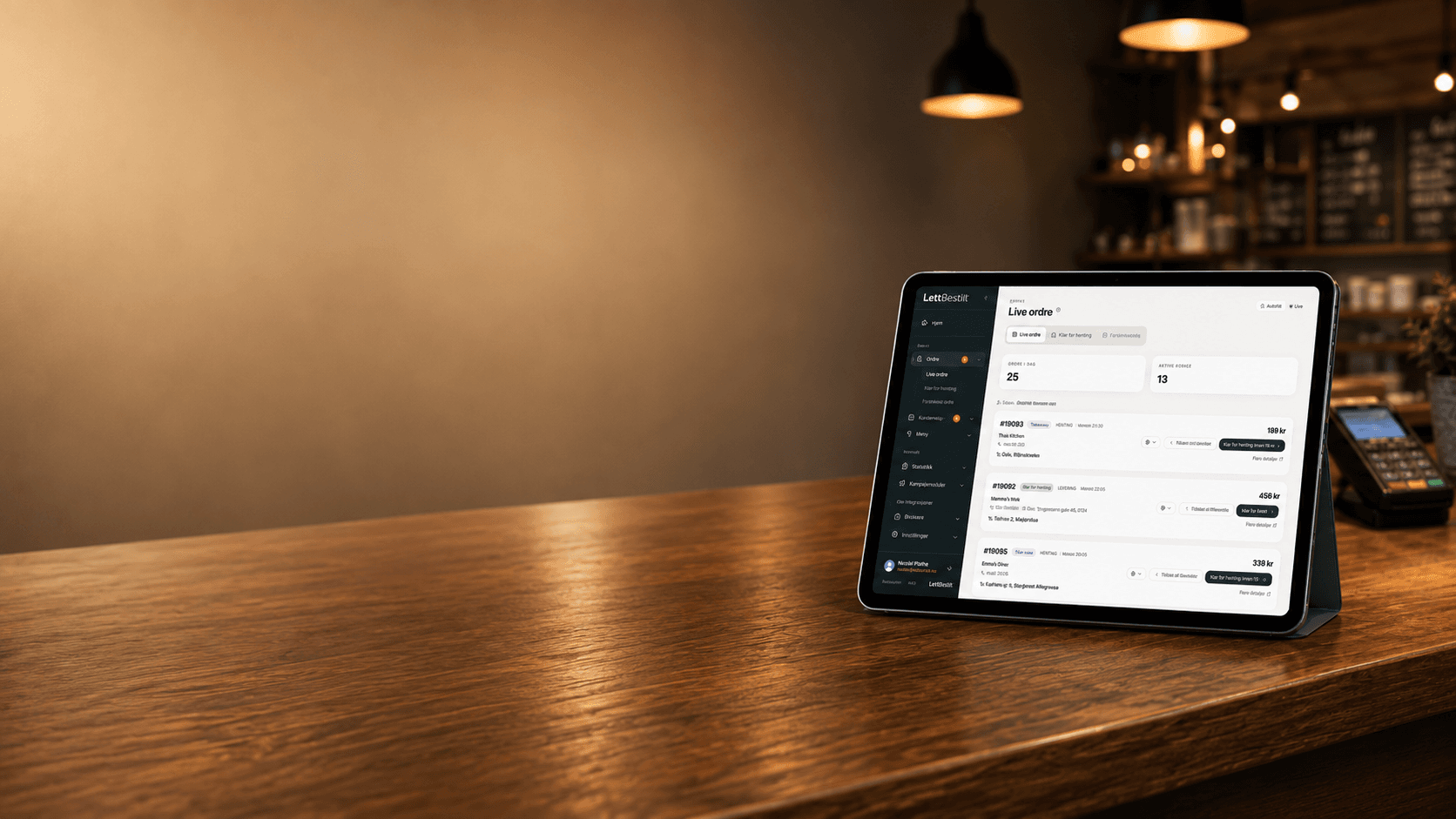 LettBestilt Live ordre-skjerm på en iPad ved siden av en kortterminal på disken i en restaurant