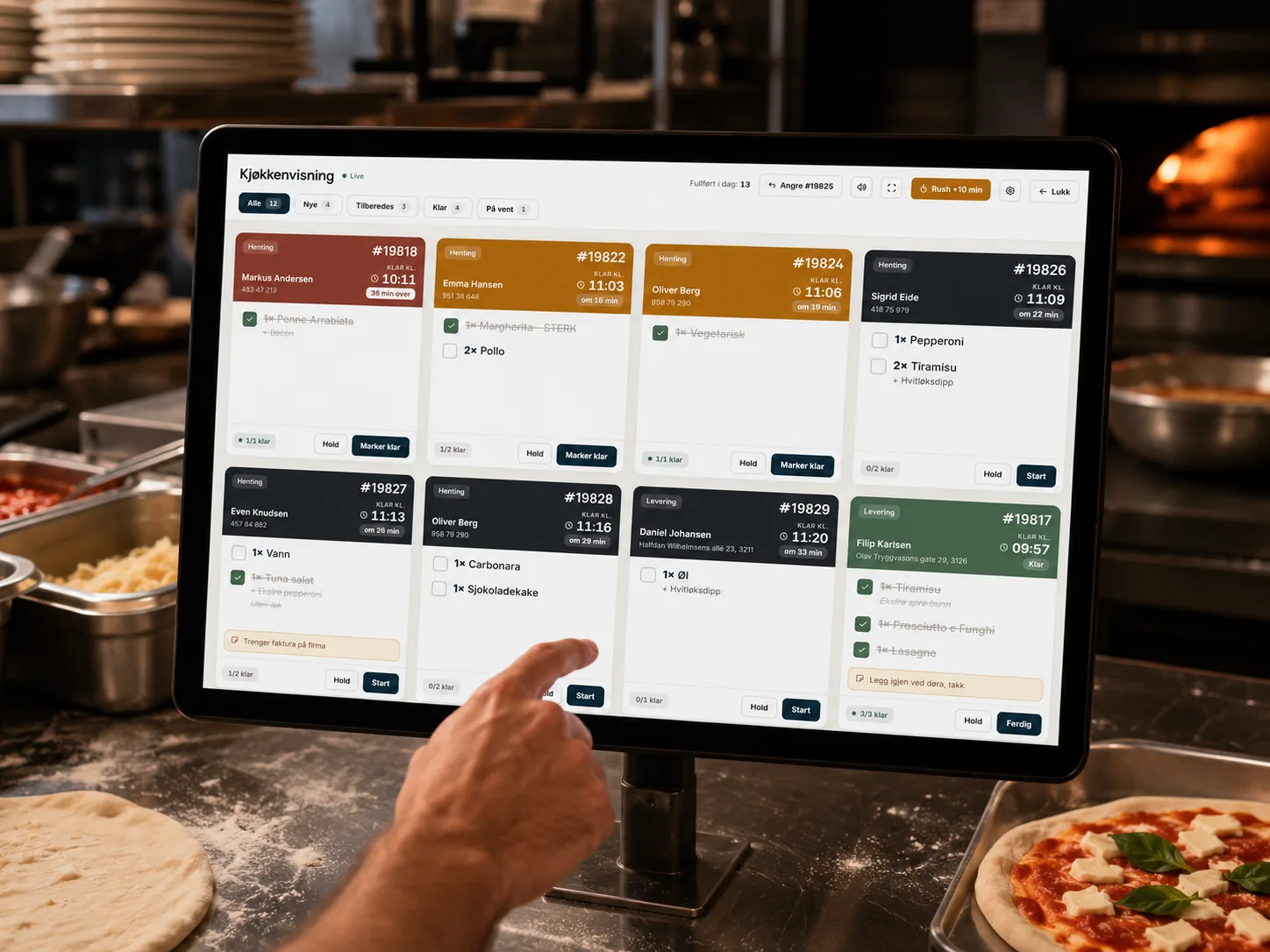 LettBestilts kjøkkenskjerm med aktive ordre, montert i et restaurantkjøkken